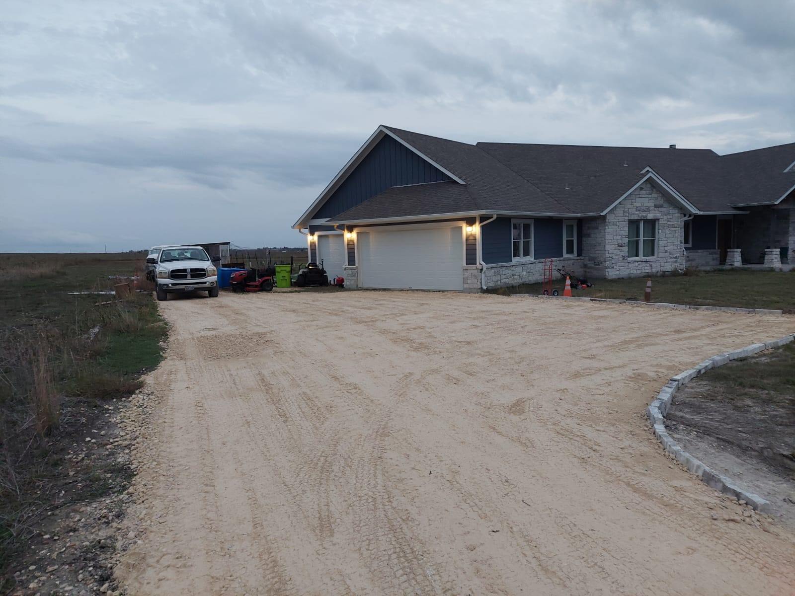 A broad aggregate driveway approaching a rural home, from the Juniors Materials gallery.