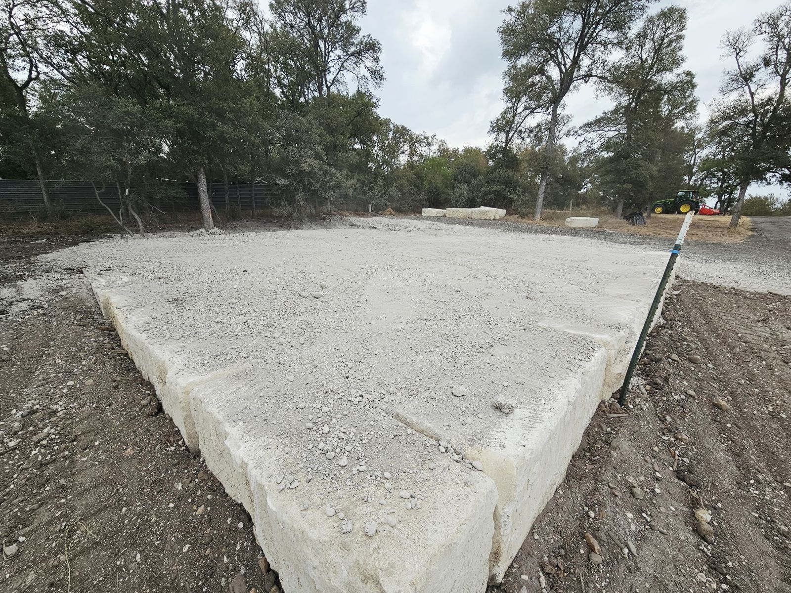 A building pad edged with limestone blocks with finished base.