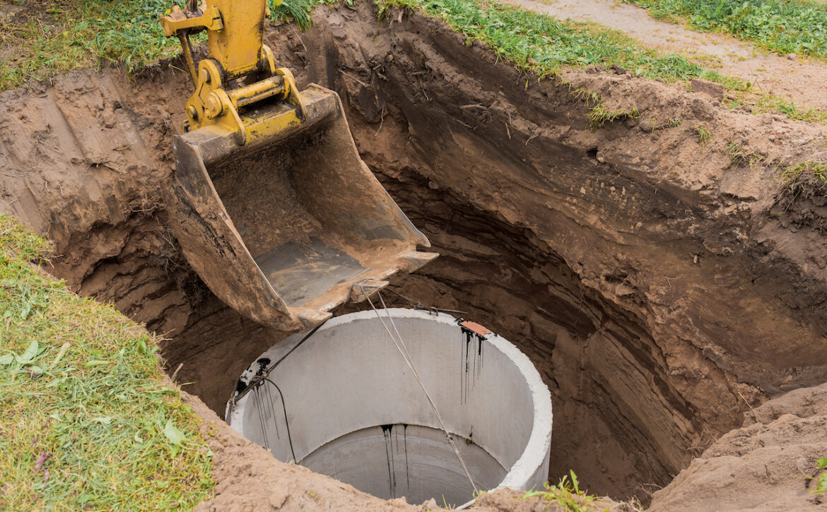 Excavator,With,A,Bucket,,Lowering,Into,The,Pit,On,Steel