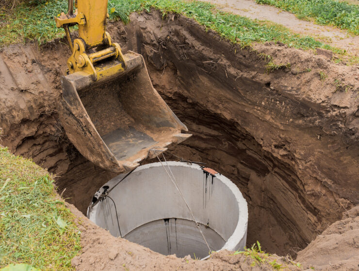 Excavator,With,A,Bucket,,Lowering,Into,The,Pit,On,Steel